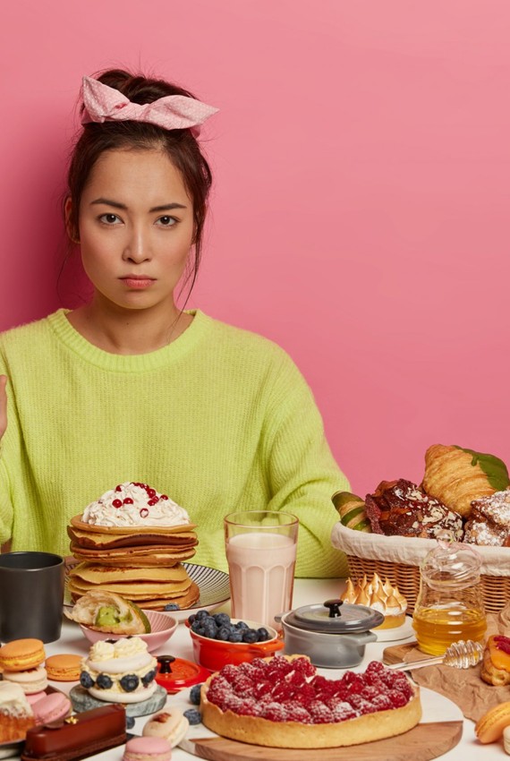 a woman sitting in front of a table full of food