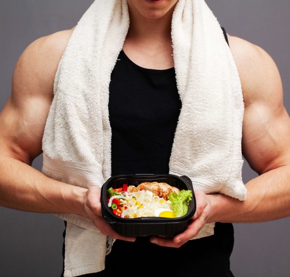 muscular man holding bowl of salad